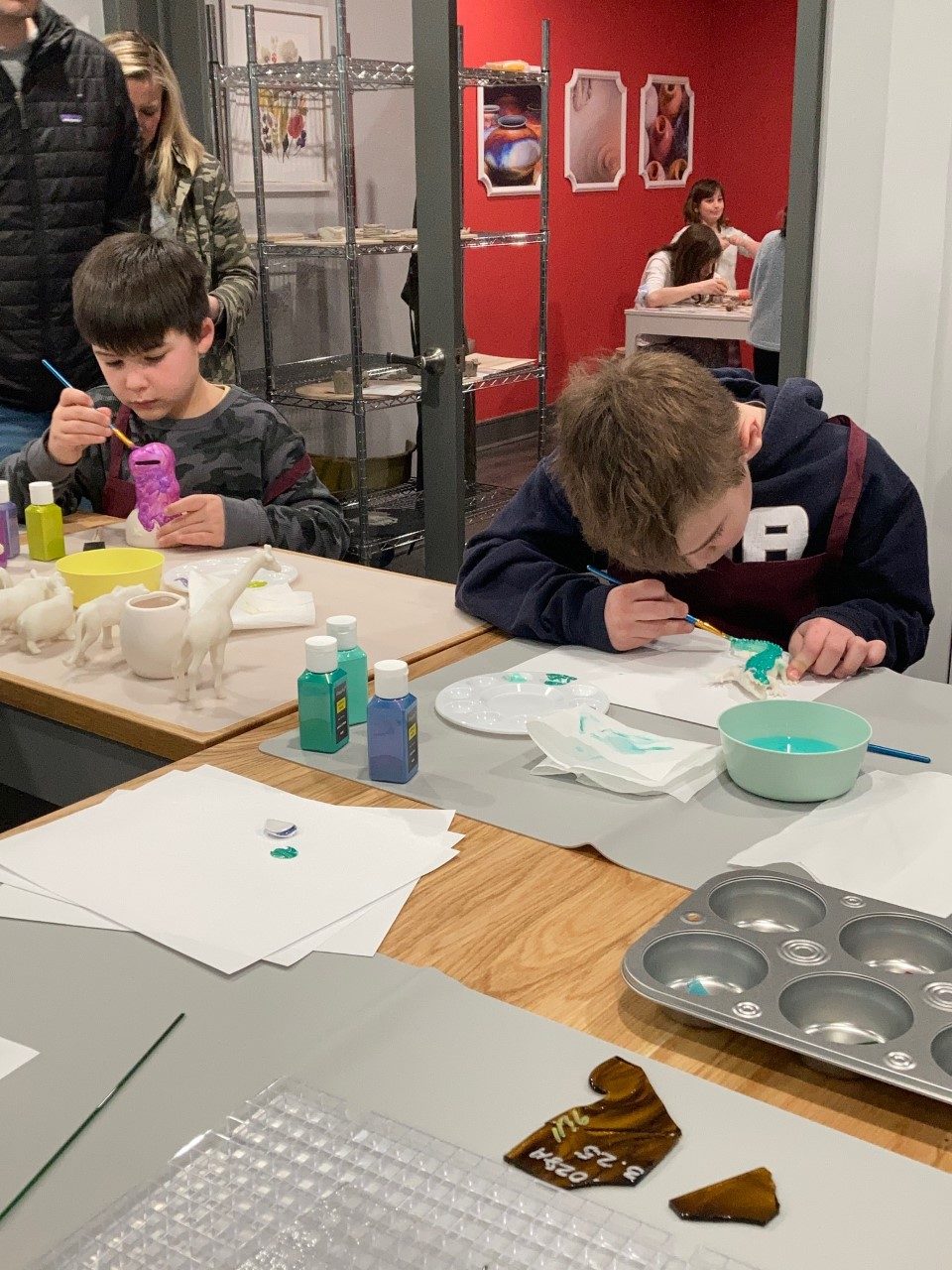 A clay studio class — kids and parents working at the table.