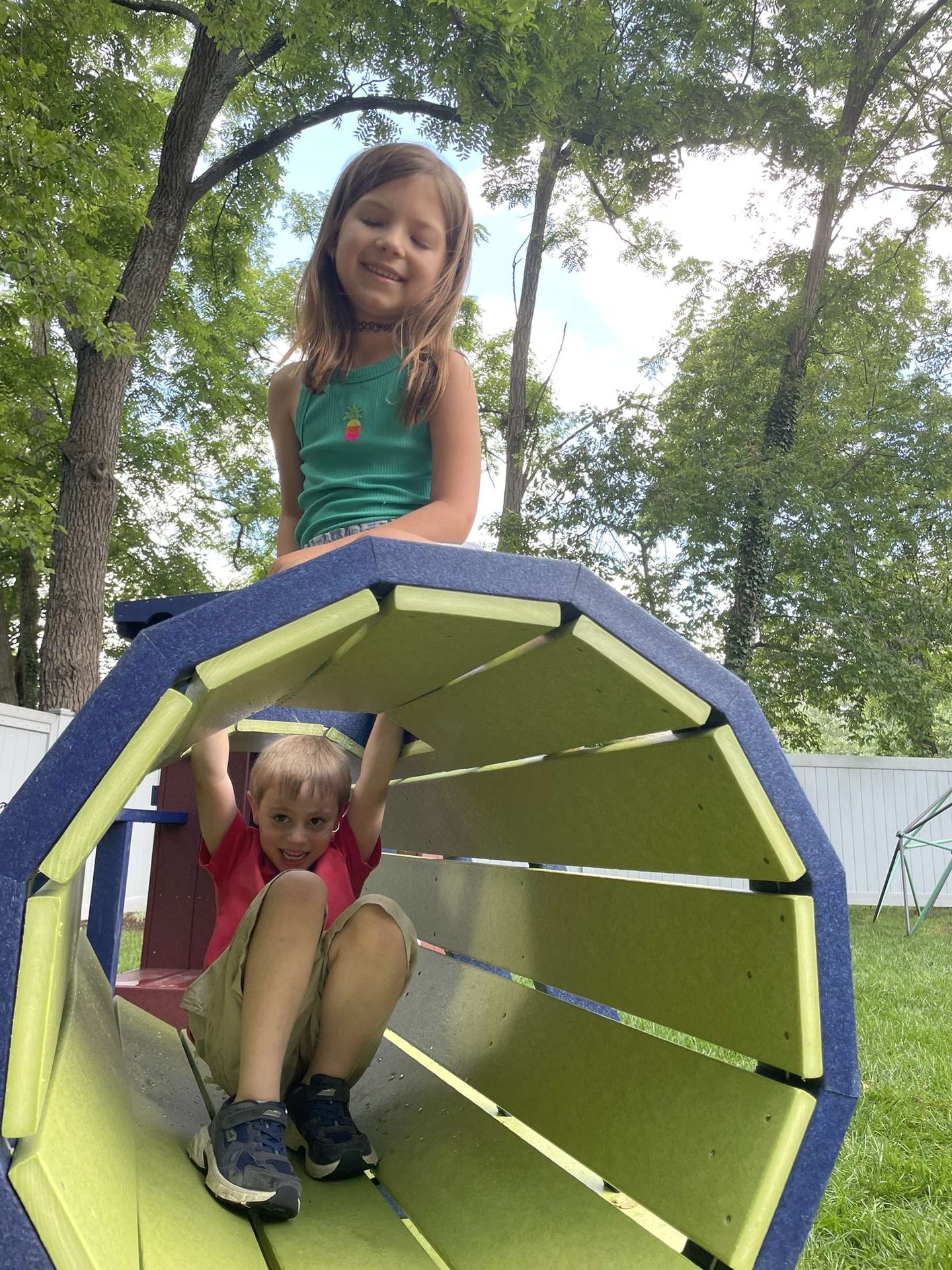 Kids inside the yellow and teal tunnel slide structure.