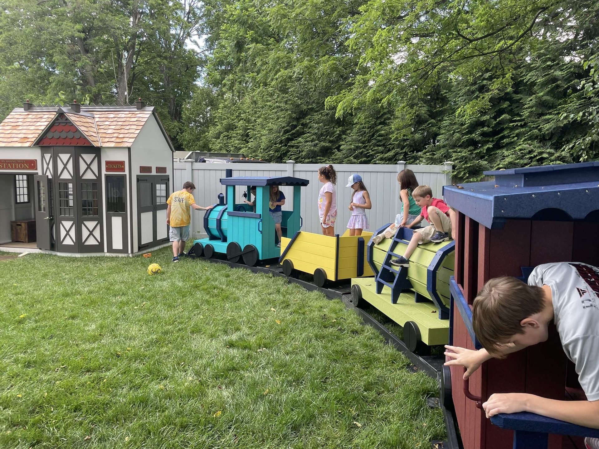 Children climbing on the outdoor train at Creative Cube.